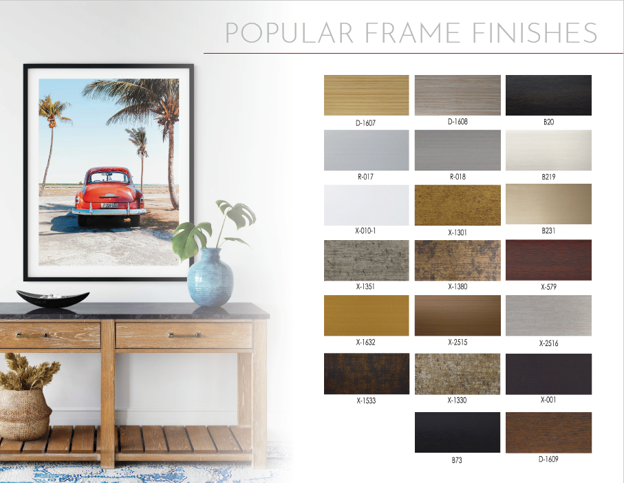 A table with a picture frame and many colors of paint.