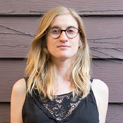 A woman with long blonde hair wearing glasses.